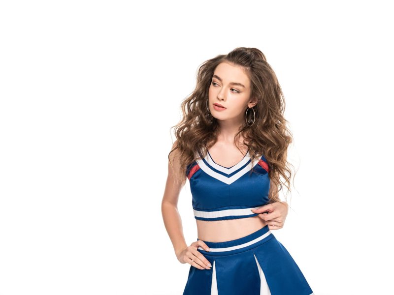 sexy thoughtful cheerleader girl in blue uniform isolated on white